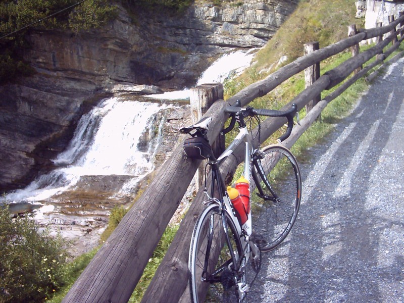 Ook een blits karretje
Halverwege de afdaling slingert de weg voorbij een waterval. Alleen is maar alleen, ook voor watervallen, daarom mijn fiets maar mee op de foto gezet.
